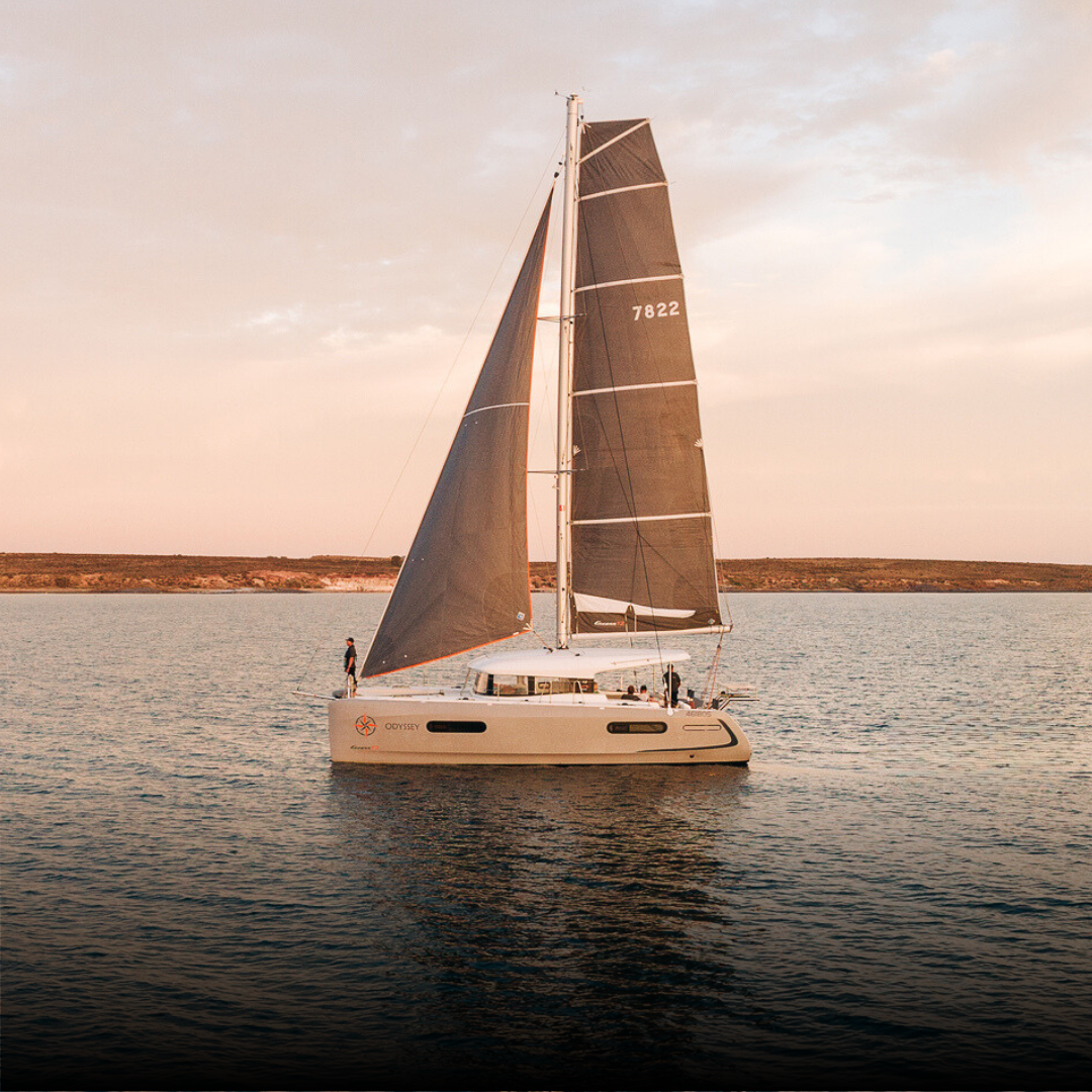 Sailboat gliding on the waters surrounding Rumi on Louth private island retreat in South Australia, with calm seas and coastal scenery in the background