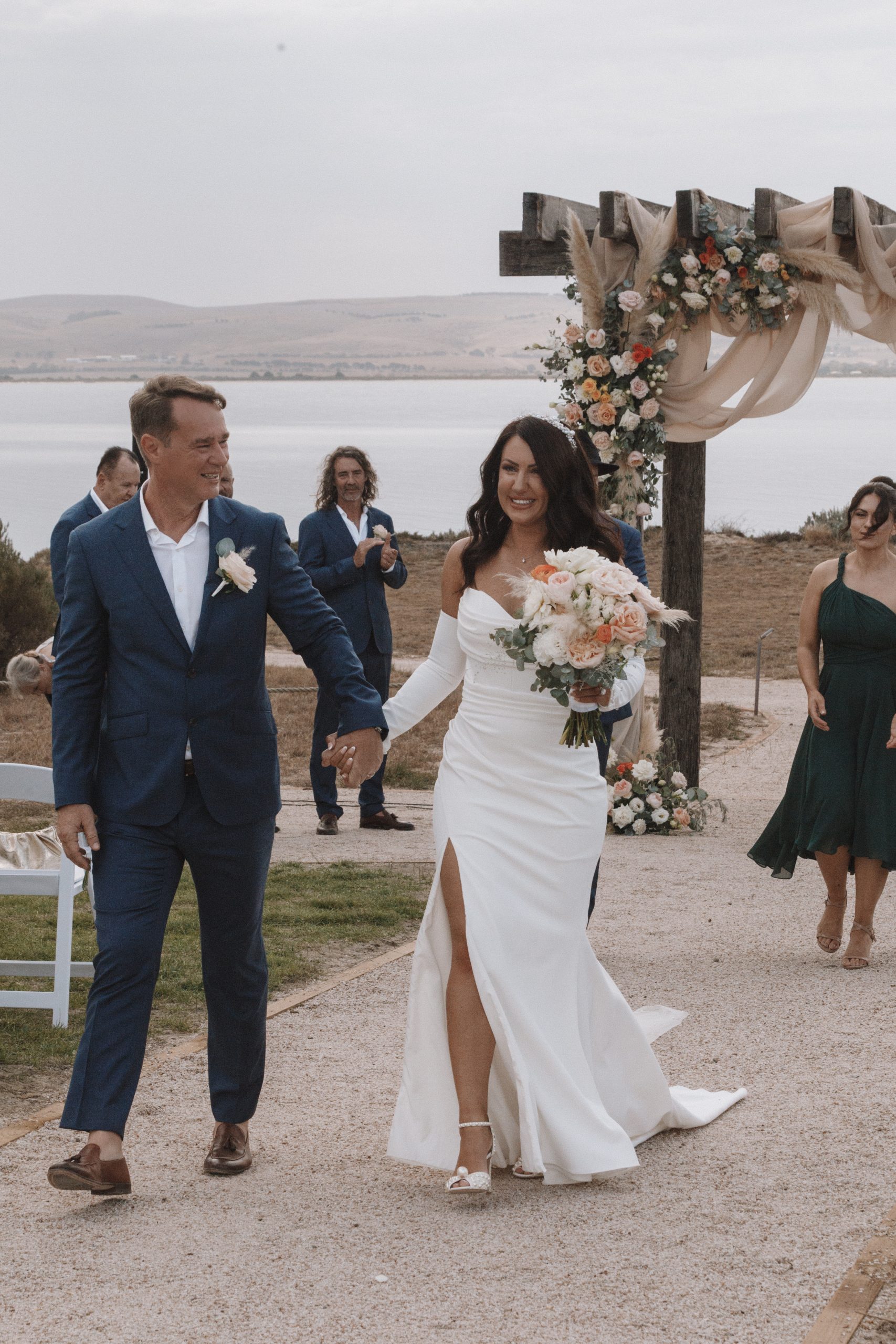 Che & Natasha Bride and groom walking hand-in-hand after their ceremony at Rumi on Louth's private island arbour